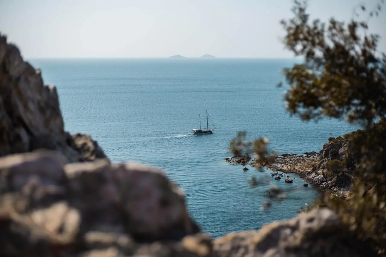 Ship going off into the ocean from a rocky coast