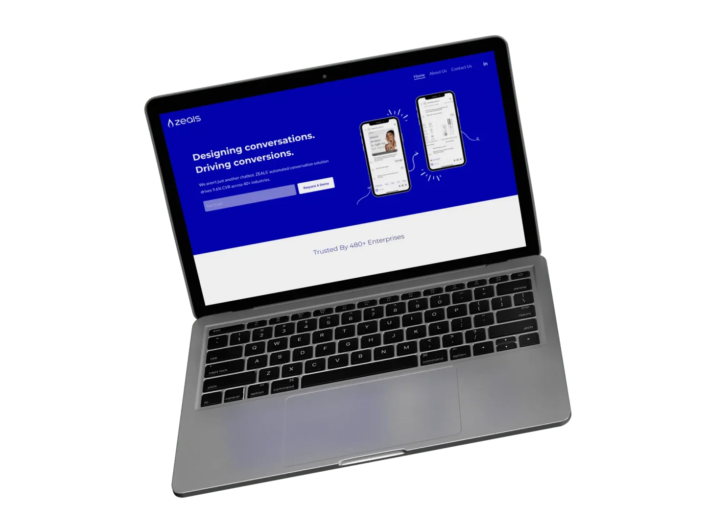 A laptop displaying a website with a blue header that reads Designing conversations. Driving conversions. and shows images of smartphones and a sign-up section. The laptop is slightly angled on a white background.