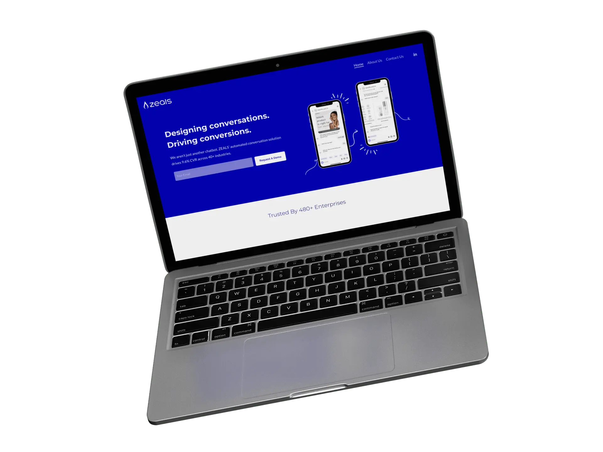 A laptop displaying a website with a blue header that reads Designing conversations. Driving conversions. and shows images of smartphones and a sign-up section. The laptop is slightly angled on a white background.