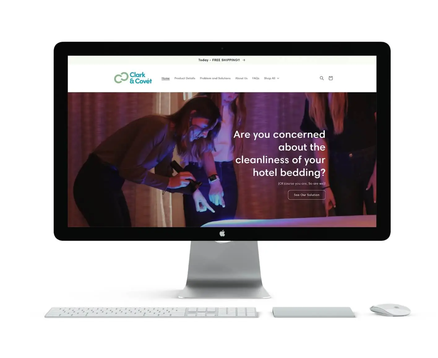 A computer monitor on a desk displays a Clark and Covét website showing people inspecting a bed with UV lights and a headline that reads, Are you concerned about the cleanliness of your hotel bedding?.