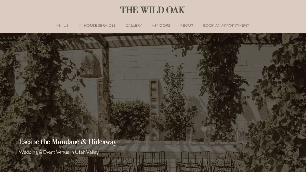 The Wild Oak Venue Portfolio 1 Outdoor patio at Wild Oak Venue features metal chairs, lush greenery, and string lights under a pergola. Highlighted as a charming wedding and event spot in Utah Valley.