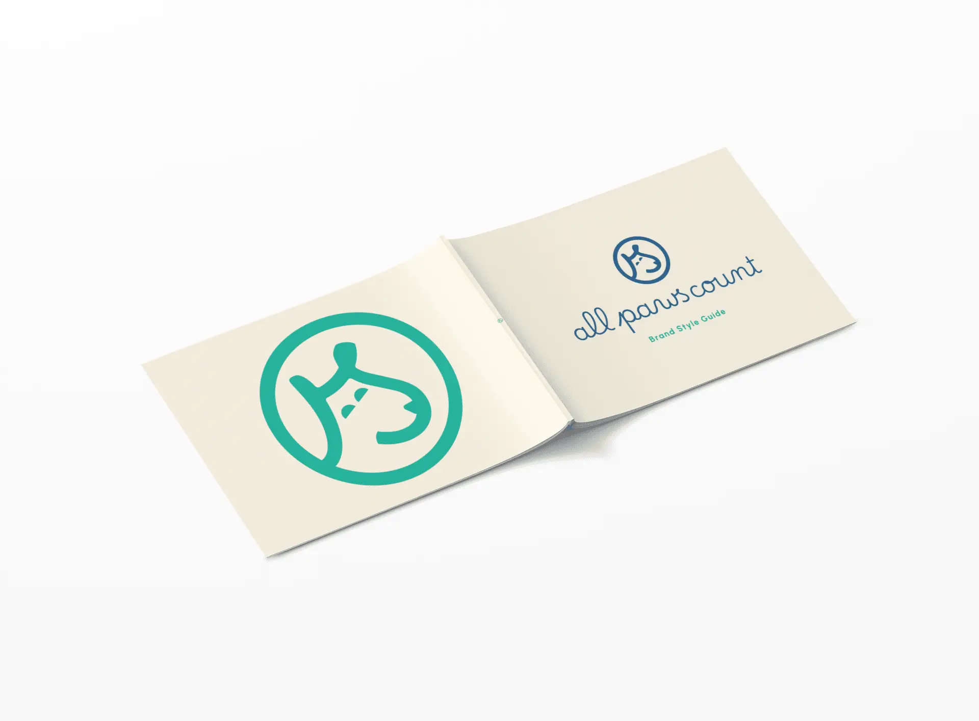 An open booklet lies on a white surface, displaying a simple teal outline of a dogs face on the left page and the text all paws count Brand Style Guide with a smaller dog face logo on the right page.