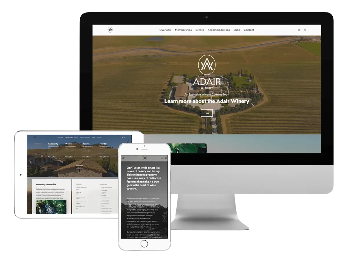 A computer monitor, tablet, and smartphone display the Adair Winery website with aerial vineyard imagery and information about memberships, events, and accommodations across the devices.