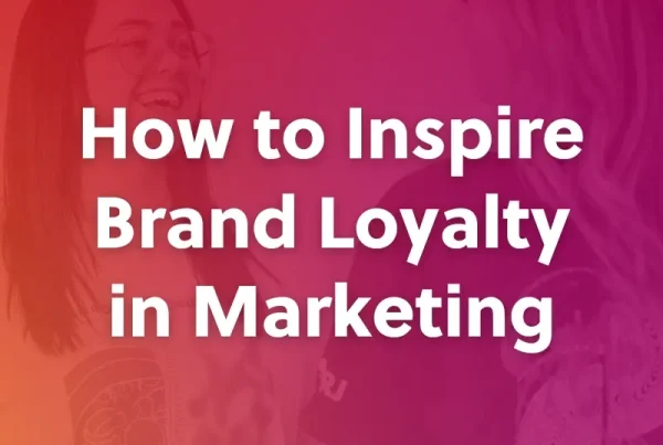 Two people smiling and facing each other with a pink-orange gradient overlay. Large white text in the center reads, How to Inspire Brand Loyalty in Marketing.