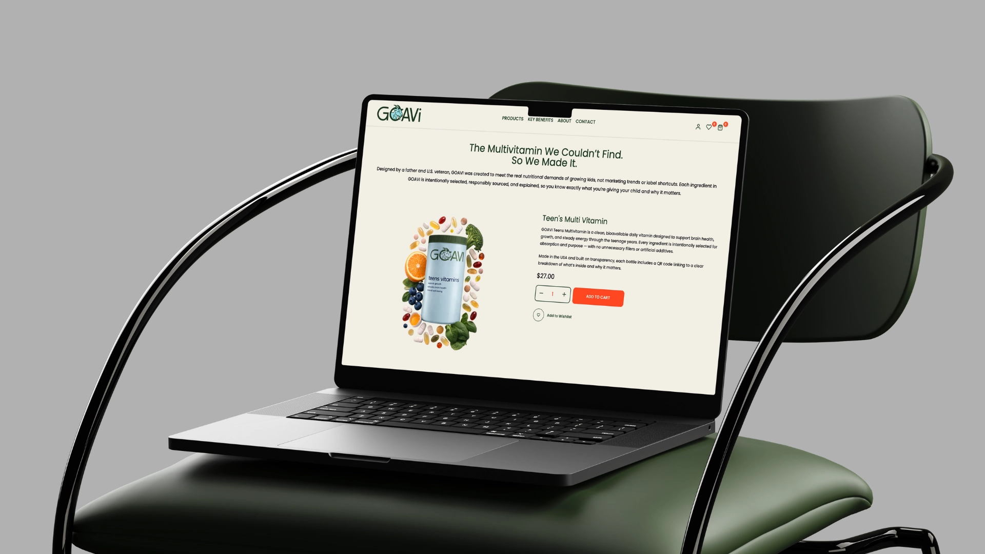 A laptop displaying a website for vitamins sits on a green chair. The screen shows a product page for a multivitamin with an image of the bottle surrounded by fruit and vegetables, and text describing the multivitamin.