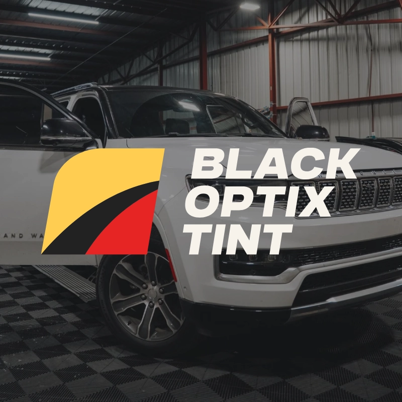 Un SUV blanco dentro de un garaje con el logotipo y el texto de Black Optix Tint, que presenta formas amarillas, negras y rojas que resaltan los fundamentos primarios del estilo automotriz audaz.