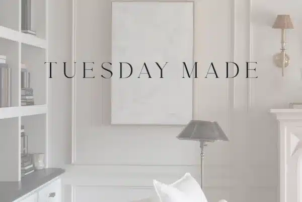 A softly-lit, elegant living room with built-in shelves, a white armchair, and a floor lamp sets the scene for Tuesday Made. A blank canvas on the wall awaits creativity, while the text TUESDAY MADE is centered over the image.