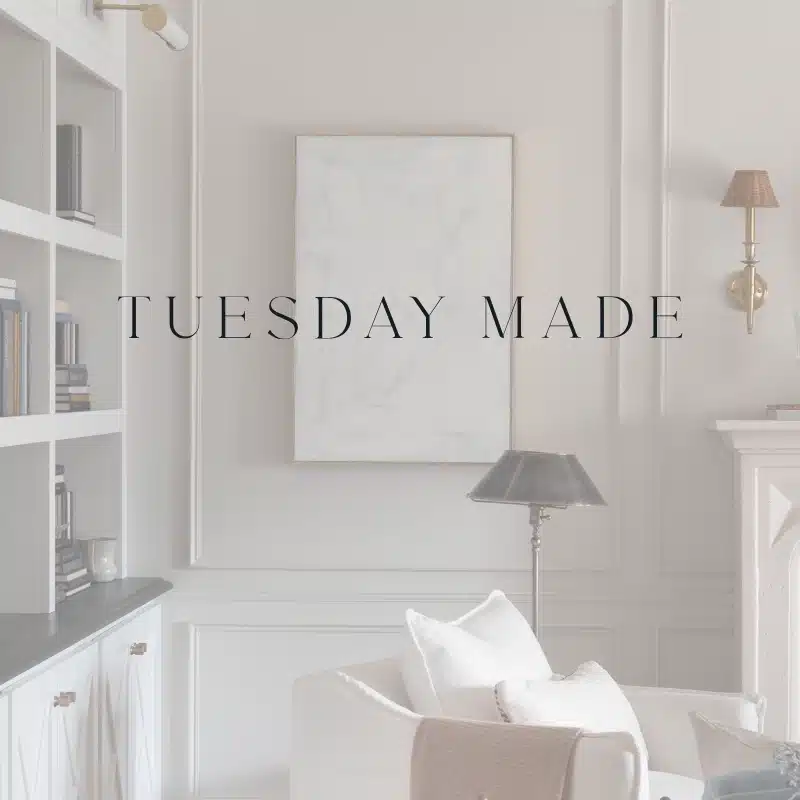 A softly-lit, elegant living room with built-in shelves, a white armchair, and a floor lamp sets the scene for Tuesday Made. A blank canvas on the wall awaits creativity, while the text TUESDAY MADE is centered over the image.