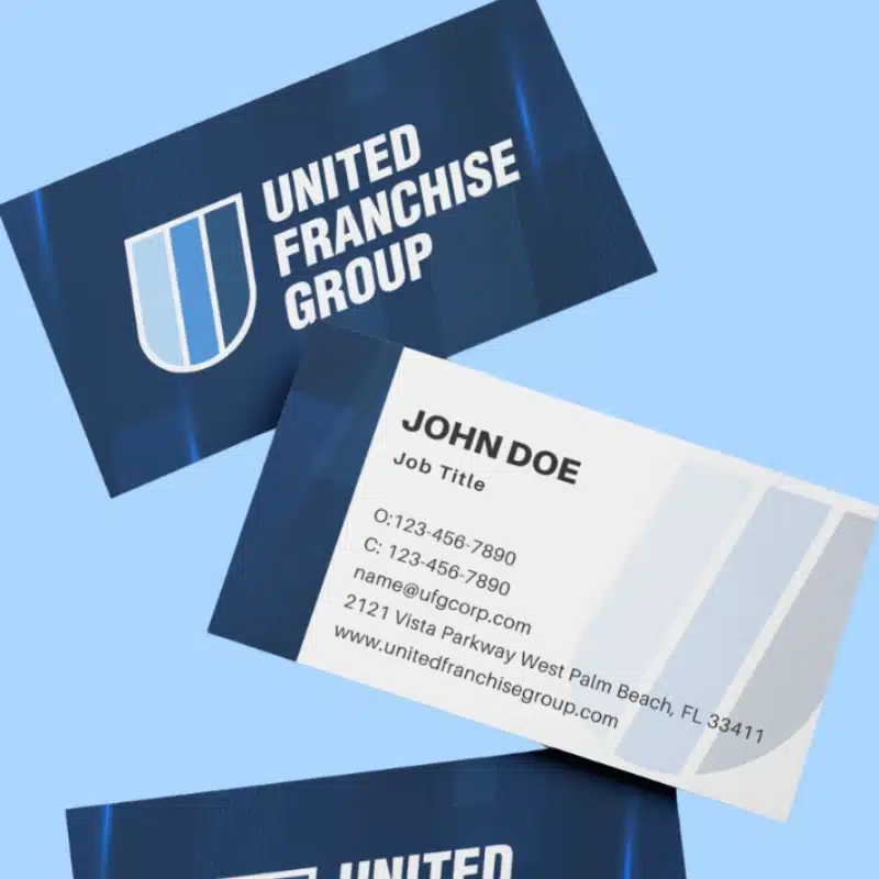 Three business cards on a light blue background display the United Franchise Group’s blue and white shield logo, along with contact details for John Doe, including phone number, email, address, and website.